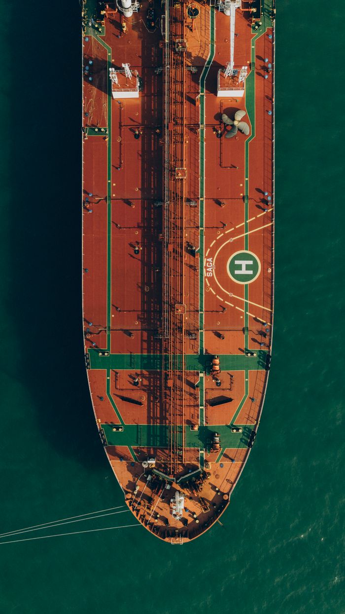 services-05 A stunning aerial view captures a large cargo ship navigating through the turquoise sea waters near Georgia.